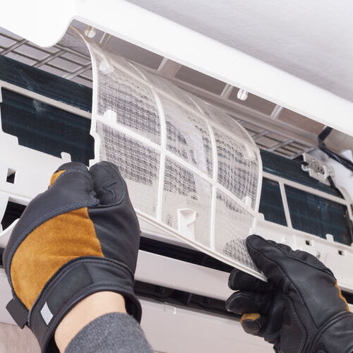 specialist cleans and repairs the wall air conditioner